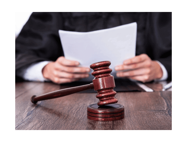 Male Judge In Front Of Mallet Holding Documents